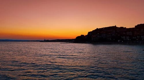 Footage over the seascape near the dark shore of the resort city.