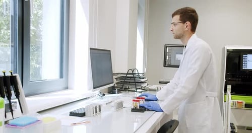 Man Laboratory Technician Working in Hospital with Modern Equipment