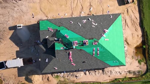 Aerial view of construction workers installing roof