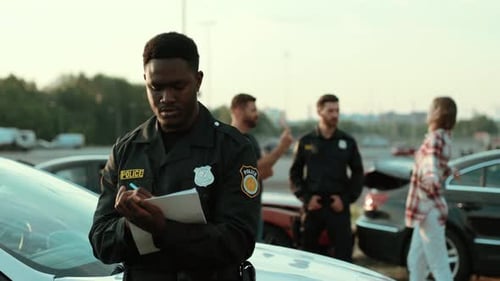 A Police Officer is Carefully Documenting the Incident That Has Occurred at the Scene