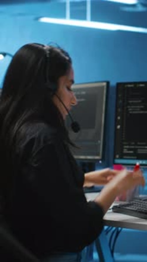 Vertical Video IT Support Worker in Remote Call Using Headset Microphone in Data Center