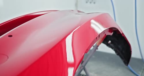 Red Car Bumper Painting in Auto Repair Shop