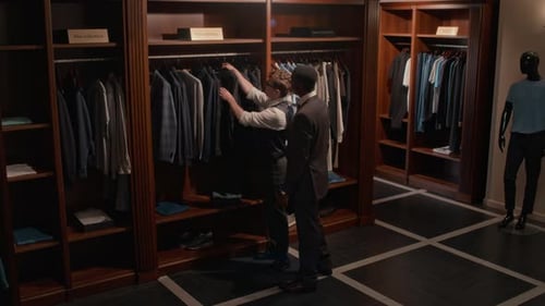 Salesman Guiding Male Customer in Clothing Store