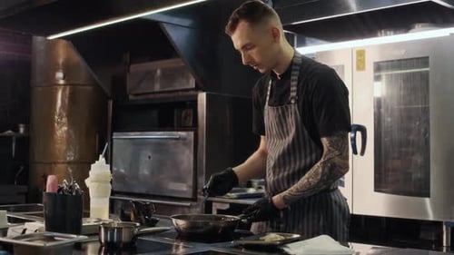 Man in Restaurant Kitchen Cooking Food