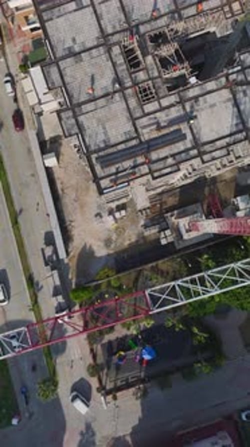 Vídeo vertical: vista aérea de equipos construyendo paredes con herramientas, mezcladoras de concreto y metal en un gran