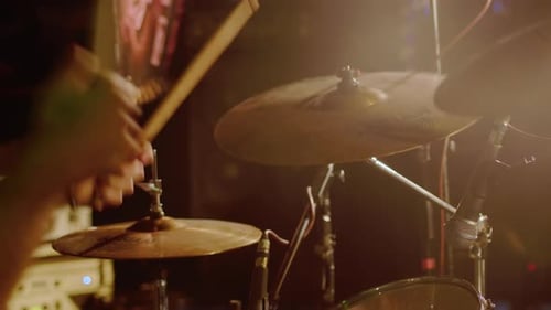 Drum Player Hits the Cymbals of the Drum Set Powerfully During the Rock Show on a Stage Under Strobe