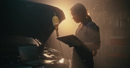 Woman Technician Troubleshooting Car Electronics With Multi Screen Setup