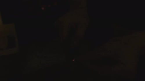 Streichholz wird gegen eine Box geschlagen, um das Spiel in einem dunklen Raum in Zeitlupe auszulösen