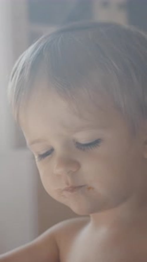 Vertical of Little Boy Sitting on Kitchen Eating