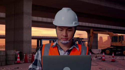 Close Up Of Asian Male Engineer Working On A Laptop At Building Site