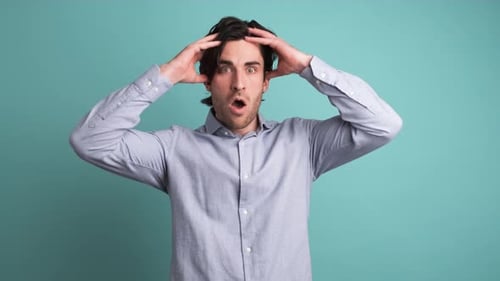 Stunned Man with Opened Mouth in Blue Studio