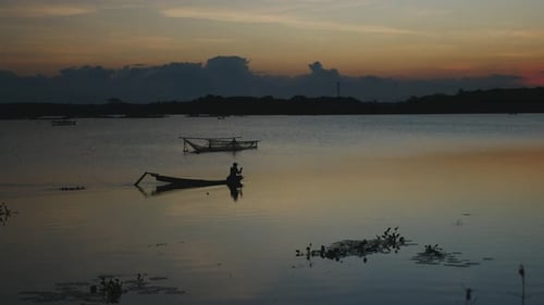 an asian man boating on the lake