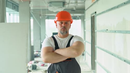 Portrait of a Confident 50s Builder in Safety Hardhat on the Construction Site of the Office