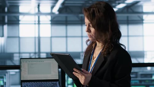 Technician in Data Center with Tablet Integrating AI Driven Automation Tools
