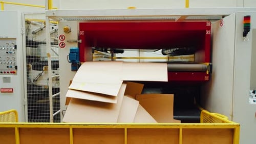 Industrial Machine Processing Large Cardboard Sheets in a Factory