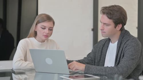 Young Couple Working on Computer in Office