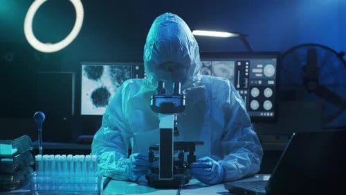 Researcher in Hazmat Suit Working With Microscope