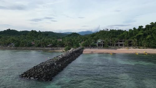 Vue aérienne en approche d'un brise-lames rocheux pittoresque prise par une communauté rurale philippine