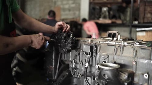 Mechanic Repairing Engine in Workshop