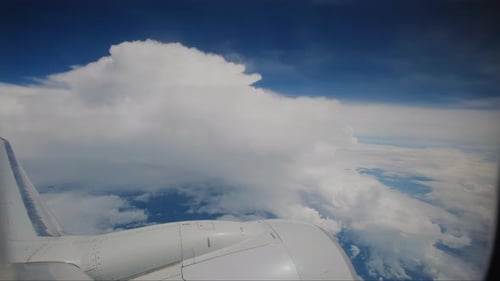 Aeronave voando nas nuvens, asa de avião e céu azul, vistas pelo passageiro através da vigia do avião