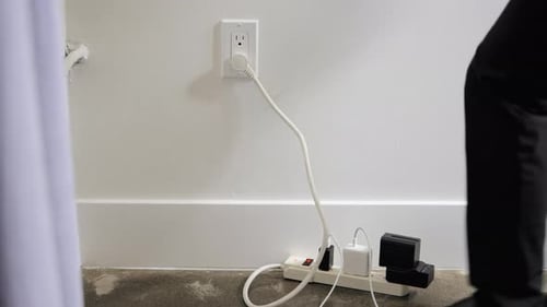 Man Unplugging The Extension Cord On Wall Socket. - close up