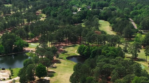 Aerial View Captures a Lush Golf Course Surrounded By Tall Trees and Tranquil Ponds The Pristine