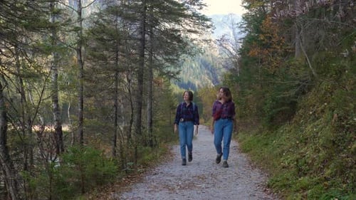 Two Girl Tourists Walking Along The Lake Shore