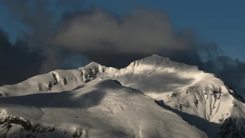Snowy Mountain Range Under Cloudy Blue Sky
