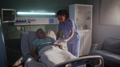 Senior Patient Cared for by Nurse in Hospital Room