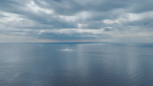 Aerial Video Aerial Sunset Over the Sea with Dramatic Clouds and Soft Light Reflections