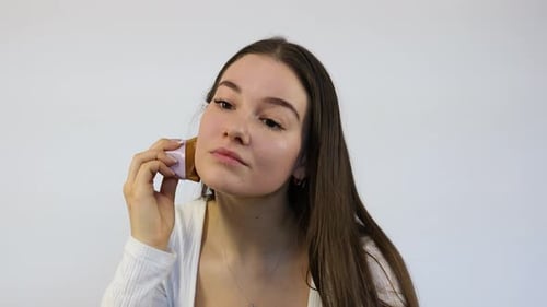 Woman Applying Makeup with Cosmetic Tool