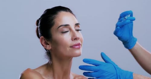 Woman, face and syringe for lip filler in studio with gloves, procedure