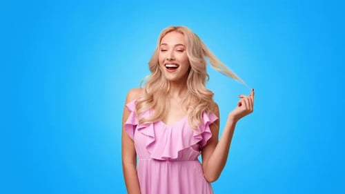 Woman Smiling Happily While Playing With Her Hair Against a Blue Background