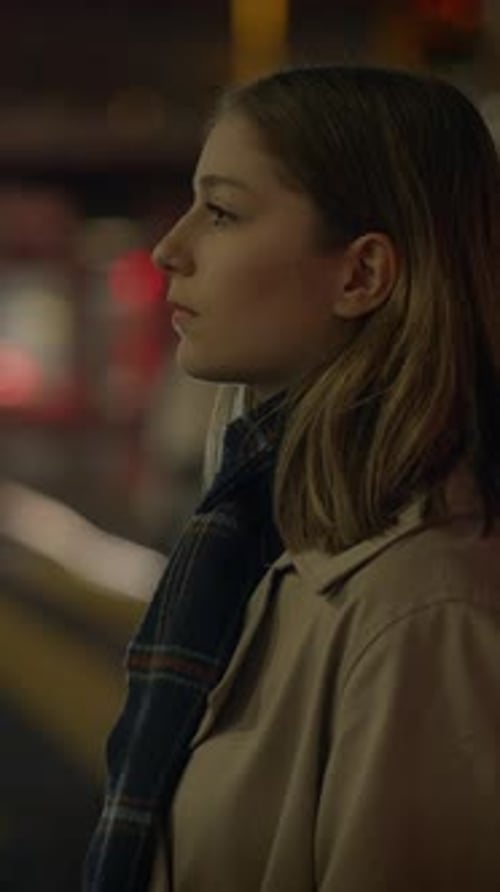 Woman Standing on City Sidewalk at Night