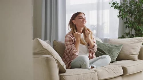 Young Woman Chatting on Sofa in Bright Living Room
