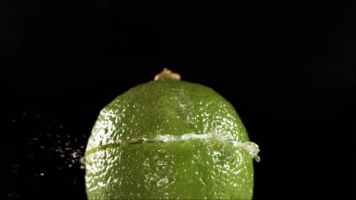 Half Lime Falling and Splashing on White Background