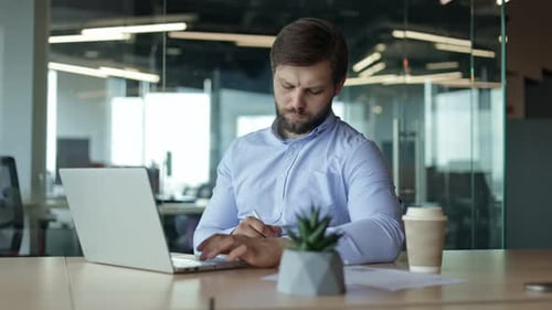 Focused Businessman Working on Laptop in Office