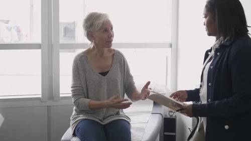 Female Doctor Discussing Medical Chart with Patient in Clinic Exam Room 10 Seconds or Greater