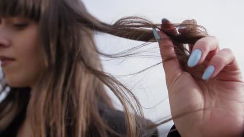 A Womans Hand Touches Her Hair Gently