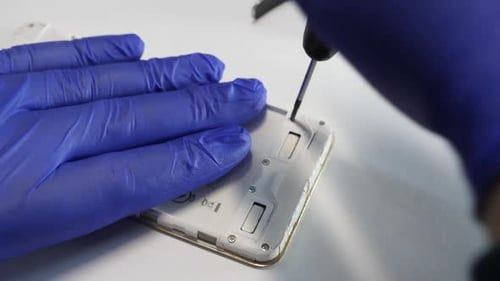 Hands Repairing Mobile Phone with Screwdriver Close Up