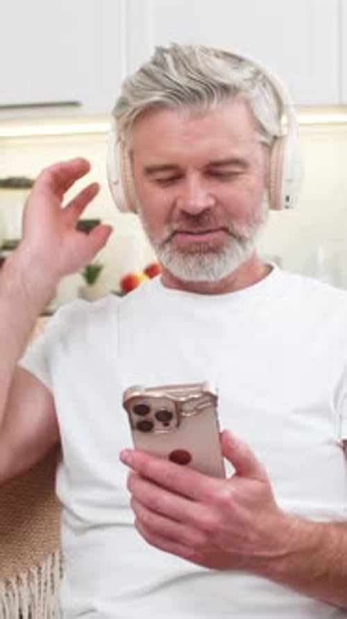 Man with Headphones Using Phone Indoors