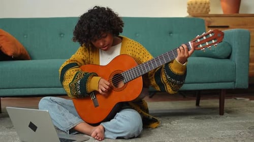 Young Woman Plays Guitar at Home