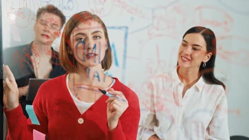 Team Discussing Ideas at a Glass Board in Office