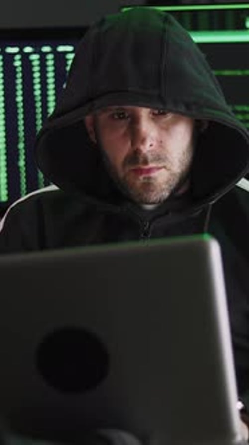 Hooded Man Working at Computer with Code