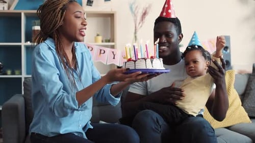 Family celebrates birthday with cake and colorful candles