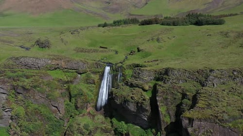 Waterfall in Iceland Aerial 4K in and down towards