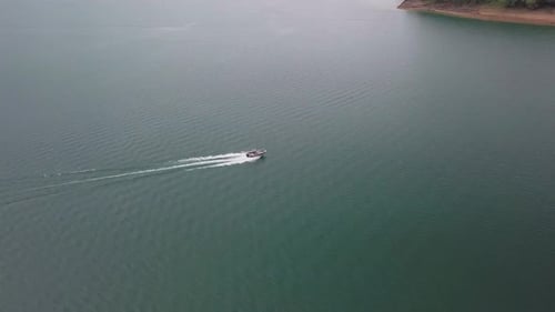 Boat speeding along a blue lake 4K