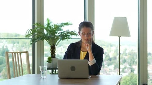 Adult Woman Working at Laptop in Bright Office