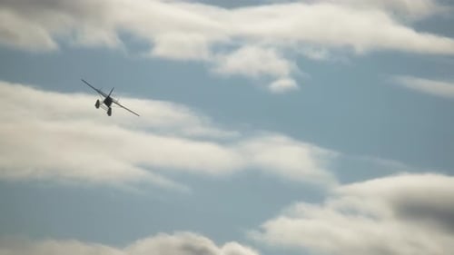Vintage Airplane Flying Through Cloudy Blue Sky