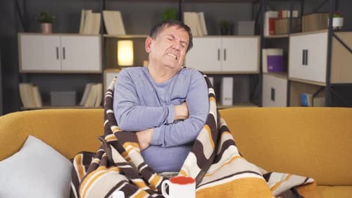 Sick Man Coughs While Sitting on Couch